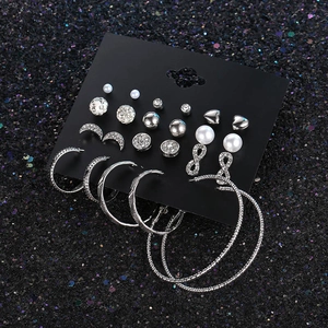 Detailed set of 12 pairs silver earrings with pearls and rhinestones on black card