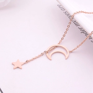 Elegant rose gold star and moon necklace in titanium steel on an open book background