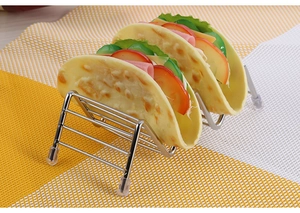 Macro view of stainless steel taco holder with four clear non-slip rubber feet