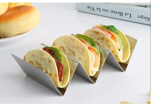 Three-slot stainless steel taco holder rack displayed with fresh tacos in a home setting