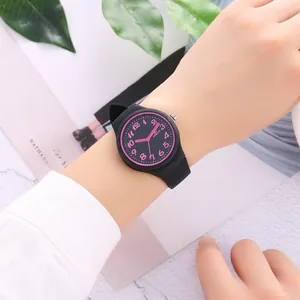Close-up of a stylish black silicone quartz watch with pink numerals on a model wrist