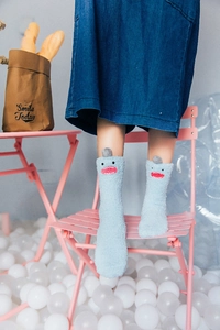 Detail of blue coral fleece socks with cute cartoon monster embroidery and grey horns