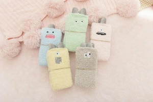 Five pairs of cute cartoon monster coral fleece socks in pastel colors on pink plush rug