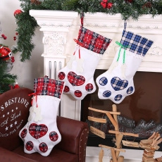 Détail de chaussettes de Noël en patte d'animal avec motif écossais et pendentif os