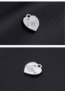 Detailed macro view of heart-shaped stainless steel pendant with Love engraving