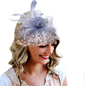 Detail of grey mesh fascinator hat with pearls and peacock feathers on a female model
