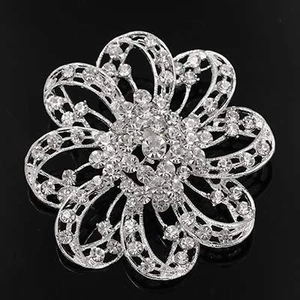 Detailed view of silver flower brooch with multi-layer petals and clear rhinestones