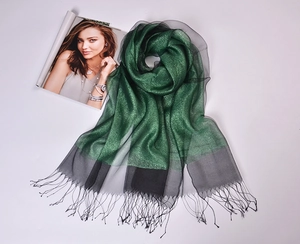 Detail of green silk organza scarf with gold thread and black tassel fringe borders
