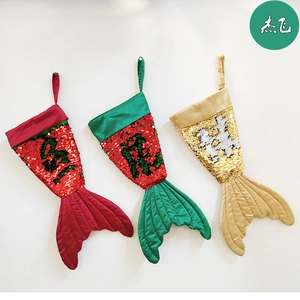 Detail of sequined mermaid tail Christmas stockings in red, green, and gold with hangers