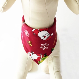 Detail of red Christmas dog bandana with cartoon Santa Claus and snowflake prints