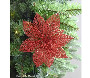 Detail of red glittered hollow flower ornament hanging on a Christmas tree branch