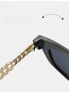 Detail of durable metal hinge on cat-eye sunglasses with gold chain temples and black frame