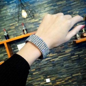Detail of a luxury five-row rhinestone silver cuff bracelet worn on a wrist in a lounge