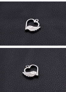 Macro detail of silver stainless steel heart with wings pendant for DIY jewelry making