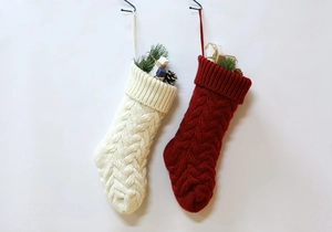 Close-up of knit Christmas stockings in cream and red with detailed cable patterns