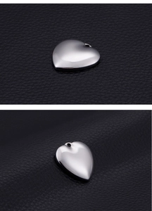 Macro-detail van de gepolijste hartvormige stalen hanger op zwart luxe leder