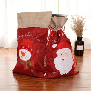 Dettaglio di sacchetti regalo natalizi in iuta con ricami di Babbo Natale e pupazzo di neve
