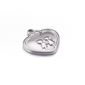 Polished silver heart pendant with boy and girl relief engraving on white background