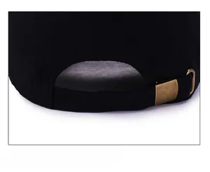 Detail view of the adjustable metal buckle and black cotton fabric on the baseball cap
