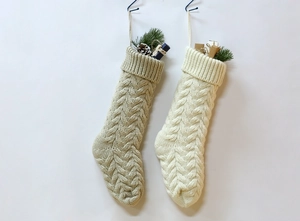 Close-up of beige and cream cable-knit Christmas stockings with hanging loops