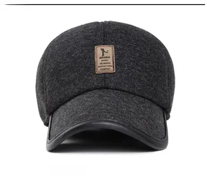 Detail of dark gray winter baseball cap showing textured fabric and leather logo patch