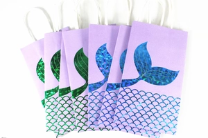 Set of five purple mermaid paper gift bags with iridescent scales and white handles