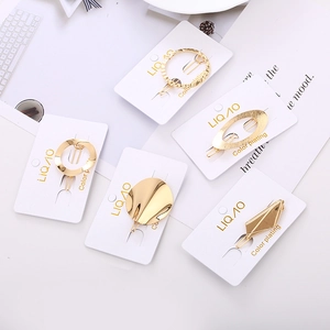 Set of 5 minimalist gold-plated geometric hair clips in round and oval shapes on display card