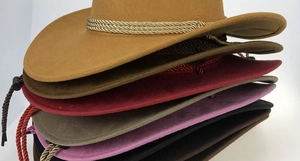 Detail view of colorful faux suede cowboy hats with woven bands and adjustable cords