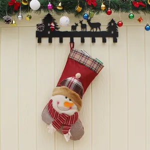 Chaussette de Noël rouge en lin avec bonhomme de neige sur fond en bois clair
