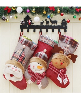 Détail de trois chaussettes de Noël suspendues avec motifs Père Noël, bonhomme de neige et élan