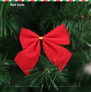 Détail d'un nœud de Noël en velours rouge avec attache dorée sur sapin, 7x6cm
