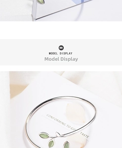 Detail of silver sprout bracelet with cat-eye leaf stones on a decorative background