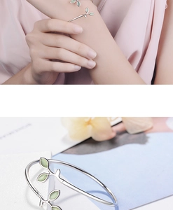 Close-up detail of silver sprout bracelet with light green cat eye leaf charms