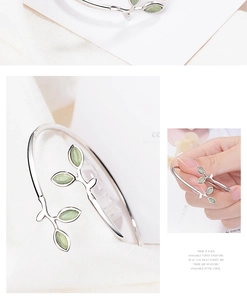 Detailed view of silver leaf open bangle with green cat eye stone in elegant macro shot
