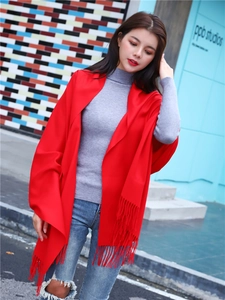 Close-up of red cashmere-feel shawl with long tassels and soft warm texture