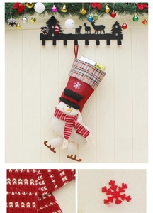 Detail of Christmas snowman stocking with red plaid collar and knitted festive textures