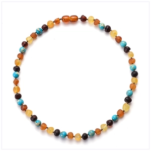 Macro detail of natural amber and turquoise beaded baby necklace on a white background