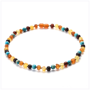 Macro shot of natural amber beads and turquoise stones on a white background