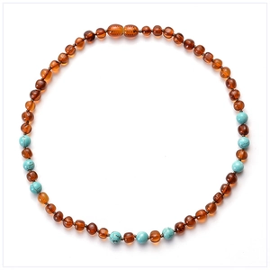 Macro shot of cognac amber beads with turquoise stones and secure screw clasp for baby necklaces