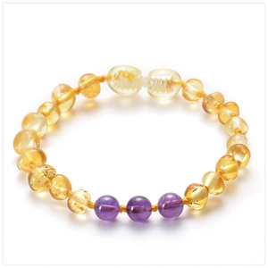 Detailed shot of Baltic amber baby bracelet with amethyst beads on a white background