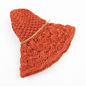 Foldable handmade straw sun hat in burnt orange with woven texture for summer beaches