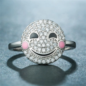 Gros plan d'une bague smiley en argent avec pavage de zircons blancs et détails roses
