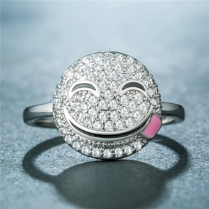 Gros plan macro d'une bague smiley en argent avec émail rose et pierres en cristal