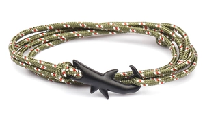 Detail of olive green paracord bracelet with a matte black shark-shaped metal clasp