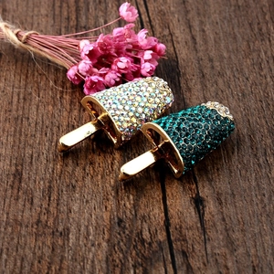 Macro view of crystal encrusted popsicle brooches in iridescent and emerald green colors