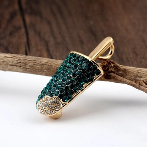 Detailed macro of a gold ice cream brooch featuring green and clear rhinestones