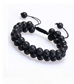 Macro detail of double-layered black lava stone energy beads on adjustable woven bracelet
