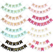 Detalle macro de las letras doradas de Happy Birthday en banderines de papel de colores