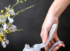 Zinc alloy squirrel nutcracker tool shown held by hand against a dark background
