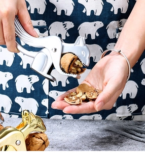 Zinc alloy squirrel nutcracker tool shown cracking a walnut in a lifestyle setting